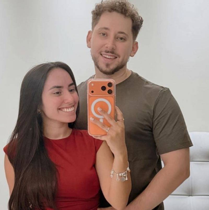 Casal de clientes sorrindo em foto no espelho