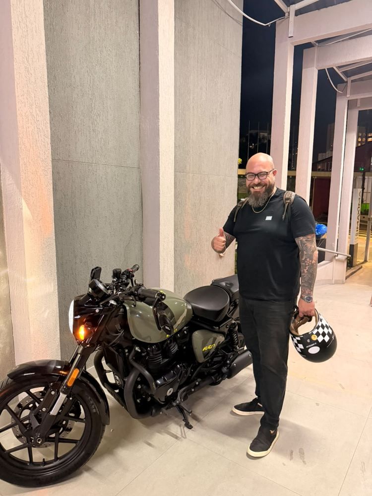 Cliente fazendo sinal de positivo ao lado da moto nova